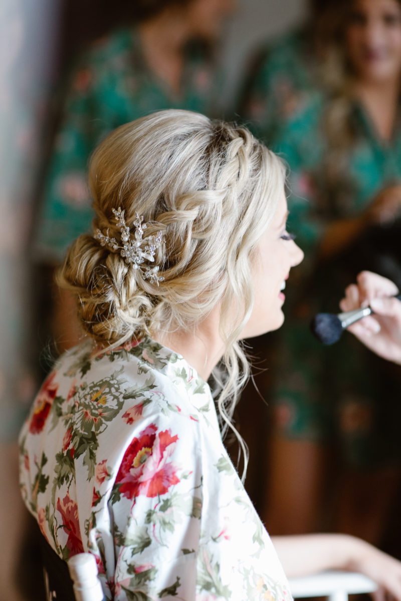 Bride getting her makeup done wearing floral robe