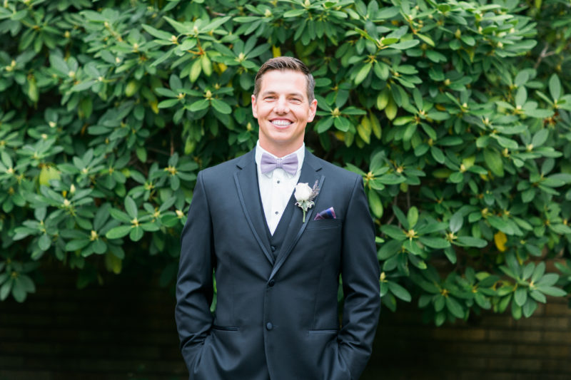 Groom smiling with purple bowtie