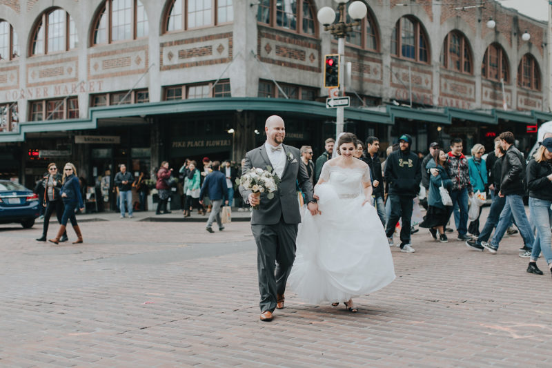 Bride and Groom walking through Pike Place Market in downtown Seattle
