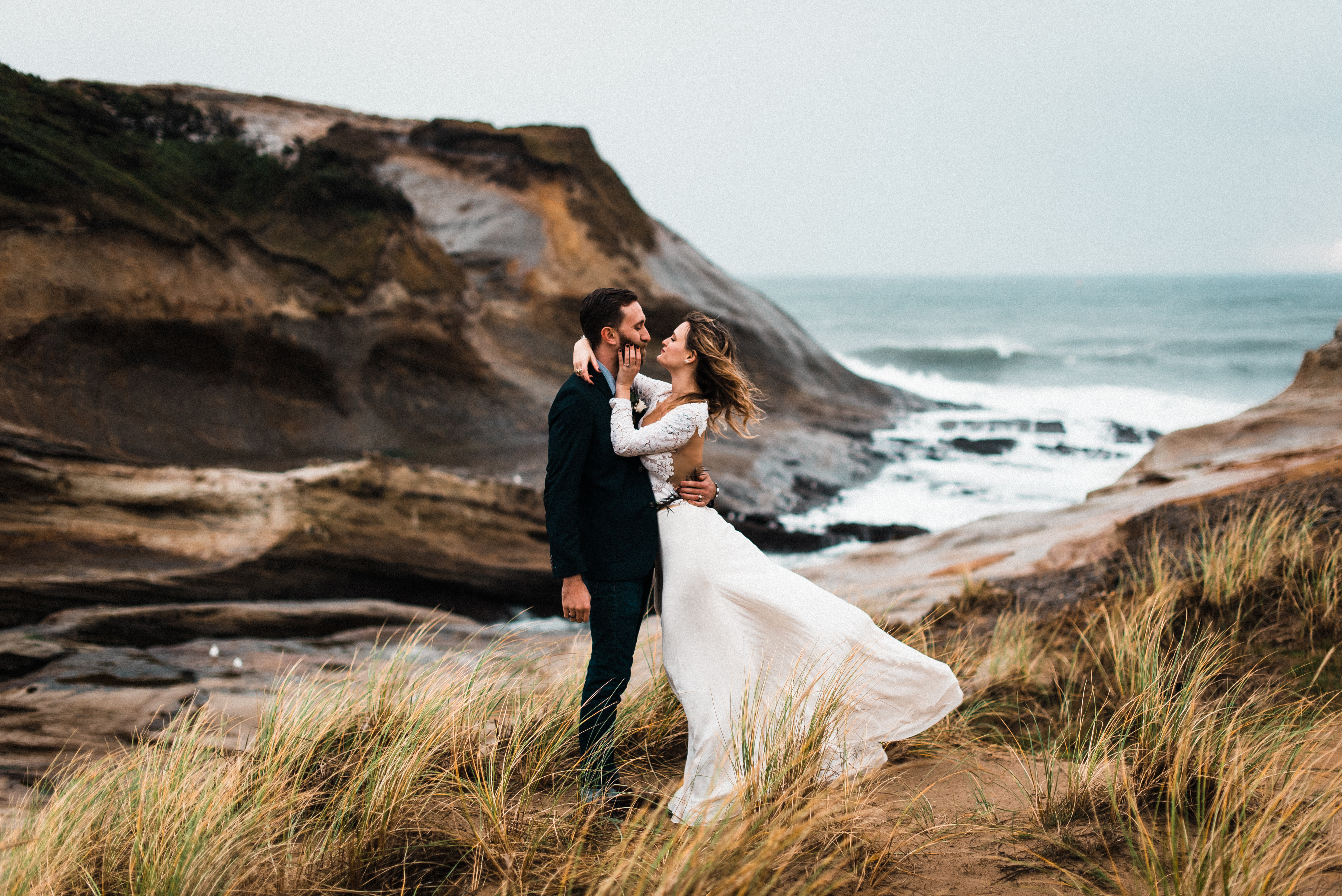 Bride and Groom elope to the Oregon Coast standing on a cliff near Cape Kiwanda Beach