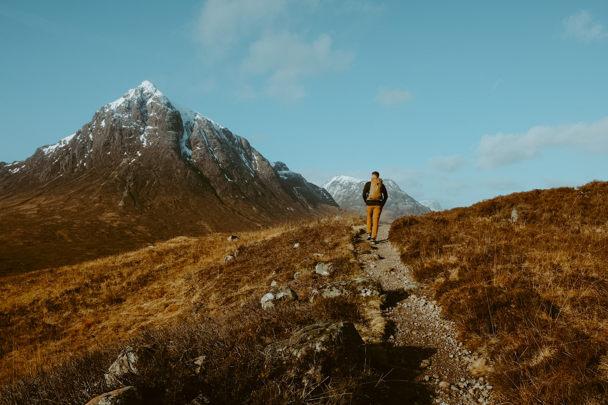Hiker in looking off into the distance at Buachaille Etive Mor in Glencoe, Scotland.