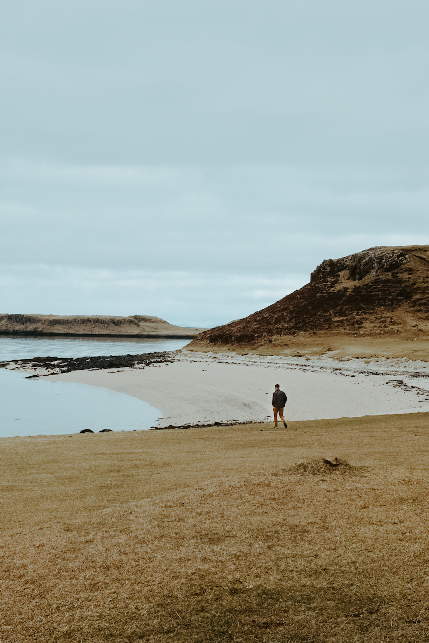 Man walking toward Coral Beach on Isle of Skye, Scotland.