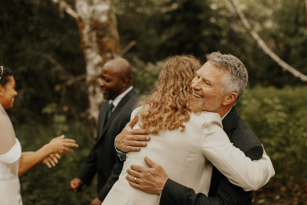 Bride hugging dad in the woods after first look reveal!