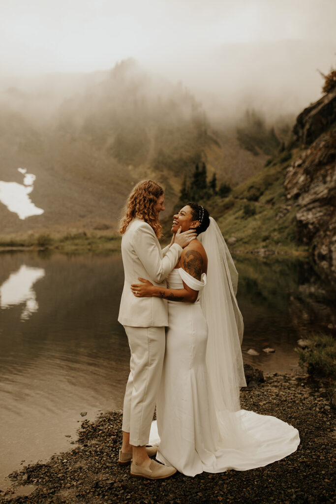 Two brides standing in the mist on the edge of Bagley Lake near Mount Baker!
